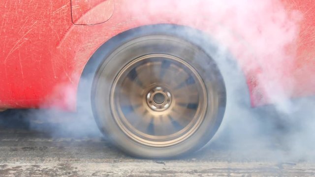 Drag car make tires warm up with smoke, Car racing burnout rubber off its tires in preparation for the race.