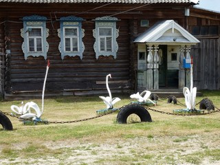 Декоративные фигуры лебедей на переднем двора перед...