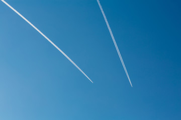 Two planes with traces on a blue sky background.