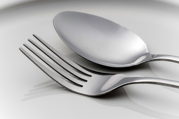 Fork and spoon on an empty plate