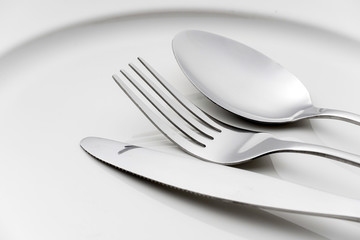 Fork and spoon on an empty plate