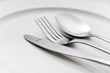 Fork and spoon on an empty plate
