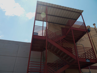 Red staircase going up side of building 