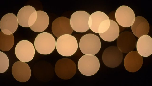 HD Footage of Blinking yellow bokeh lights moving fast and slow.