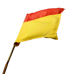 A red and yellow beach safety flag swaying in the wind