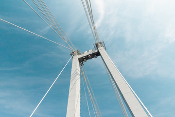 Fototapeta premium cable-stayed bridge closeup against a blue cloudy sky , abstract structure background