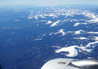 aerial view of snow mountain range with plane engine
