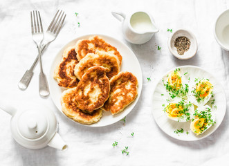 Served brunch - potato scones and boiled eggs on a light background, top view. Delicious breakfast, snack, appetizer