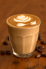 Coffee piccolo latte on wooden desk in coffe's shop