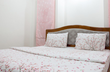 Close up white pillow and bedding sheets on natural white wall bedroom background, Messy bed concept