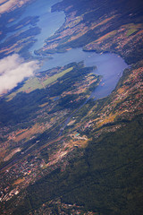 Landscape, the surface of the earth through the clouds from an airplane window.