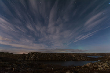 Fototapeta na wymiar Night sky with clouds and stars and lake.
