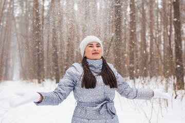 Obraz premium Young pretty woman throwing snow in the air in winter holidays