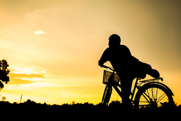 Fototapeta na wymiar A boy fitness silhouette sunrise cycling workout wellness concept