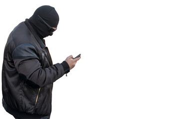 a man, a terrorist, a bandit in a black leather jacket and a mask talking on the phone