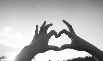 Fototapeta premium Hands in heart form love, silhouette hand make heart form with sun set