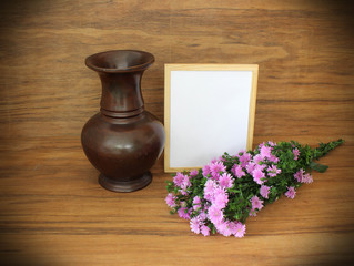 vintage wooden  vase and blank frame on wooden table with purple flowers