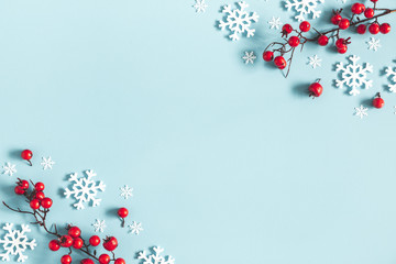 Christmas or winter composition. Frame made of snowflakes and red berries on pastel blue background. Christmas, winter, new year concept. Flat lay, top view, copy space - 232752250