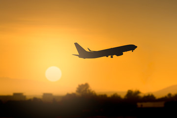 Naklejka na ściany i meble Silhouette airplane takeoff at sunset