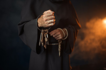 Medieval monk holds a bunch of keys in hands - obrazy, fototapety, plakaty