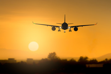 Fototapeta na wymiar Silhouette airplane takeoff at sunset