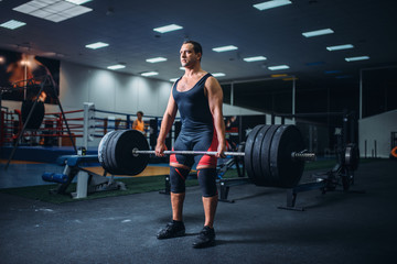 Powerlifter keeps the weight of heavy barbell
