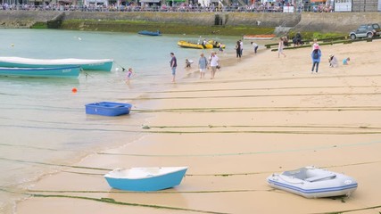People walking along St Ives beach and enjoying the summer.