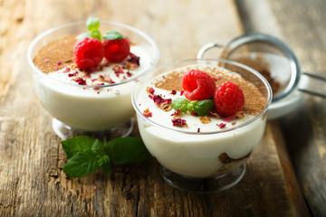 Homemade tiramisu dessert decorated with fresh raspberry and rose petals