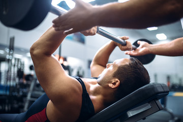 Athlete lies on bench, exercise with barbell