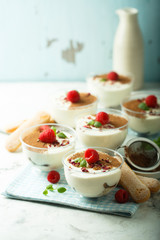 Homemade tiramisu dessert decorated with fresh raspberry and rose petals