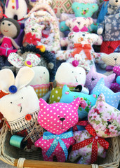 Fototapeta na wymiar Colorful textile toys sitting in basket, fair for tourists, on sale