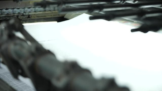 The work of a professional printing press in the printing house. The camera moves from right. Offset printing machine.