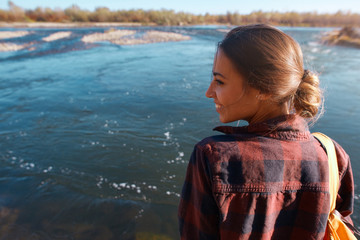 young smiling woman tourist on the mountain river background. Hipster girl near the mountain river