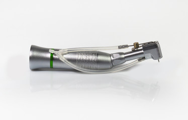 Low speed handpiece for dental implantology on mirror background