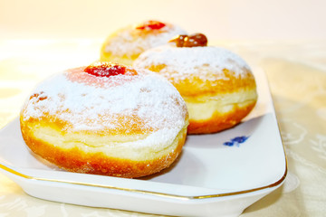 Hanukkah Sufganiyah (Sufganiyot in Israel). Hanukkah (Chanukah) - Jewish Holiday. Sufganiyah - Festive Donut. Image of Jewish Holiday Hanukkah. Hebrew tablecloths inscriptions: Holiday