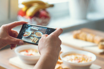 Closeup how woman taking photo of vegetarian food at home