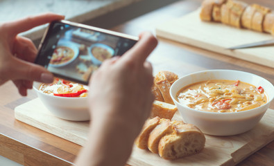 Closeup how woman taking photo of vegetarian food at home