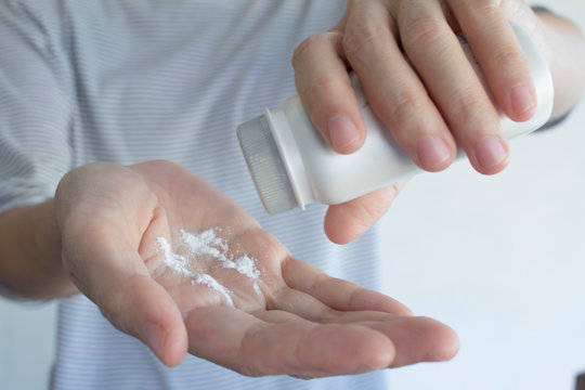 A Woman Is Taking Talcum Powder To Her Hand