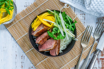 Hoisin duck with mango, spring onion, rocket lettuce salad and rice - top view