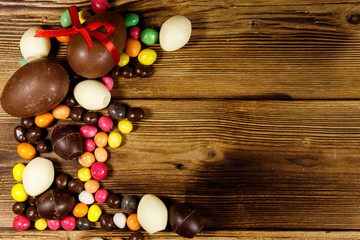 Easter composition with chocolate eggs on wooden background