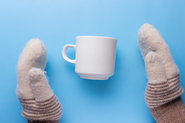 Woman hands in mittens hold cup of hot tea