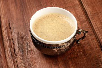 Coffee in a vintage cup on a dark rustic wooden background with copy space