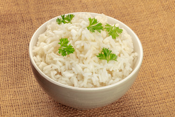 A bowl of cooked white long rice on a burap background with a place for text, slightly toned image