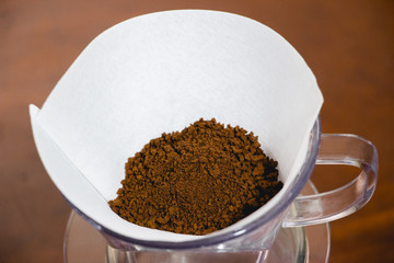 Drip coffee with paper filter tool on wood background
