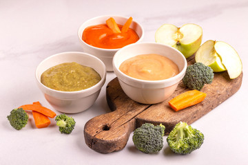 Variation pureed baby food in clay bowls with ingredients