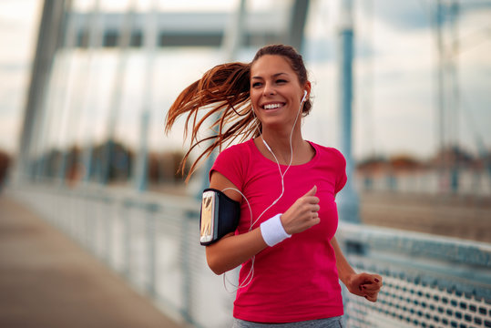 Young fitness woman running in the city
