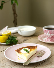 Healthy breakfast made from soft cottage cheese casserole with oatmeal and lemon zest, served with sour cream and mint.