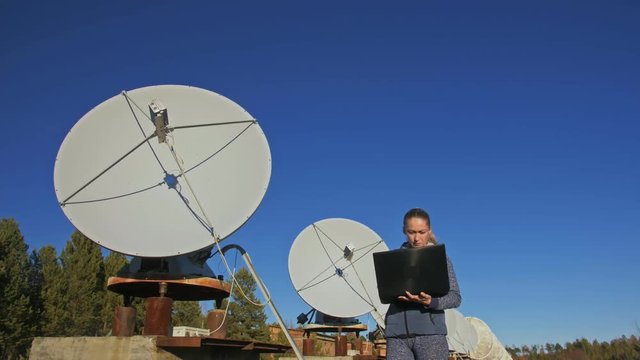 Woman student operator of institute of Solar Terrestrial Physics monitors communication equipment in notebook. Unique array solar radio telescope. Sun Solar Radio Telescope. The 'Quasar' observatory