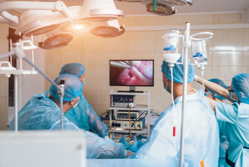 Process of gynecological surgery operation using laparoscopic equipment. Group of surgeons in...