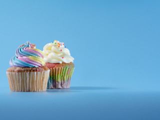 Colorful and enteresting cupcake isolated on blue background studio close up shot.